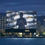 【M+幕牆全新作品】首個本地藝術家作品   流動影像結合真人表演和科幻片段    以心經手語光照維港   盼港人渡過難關