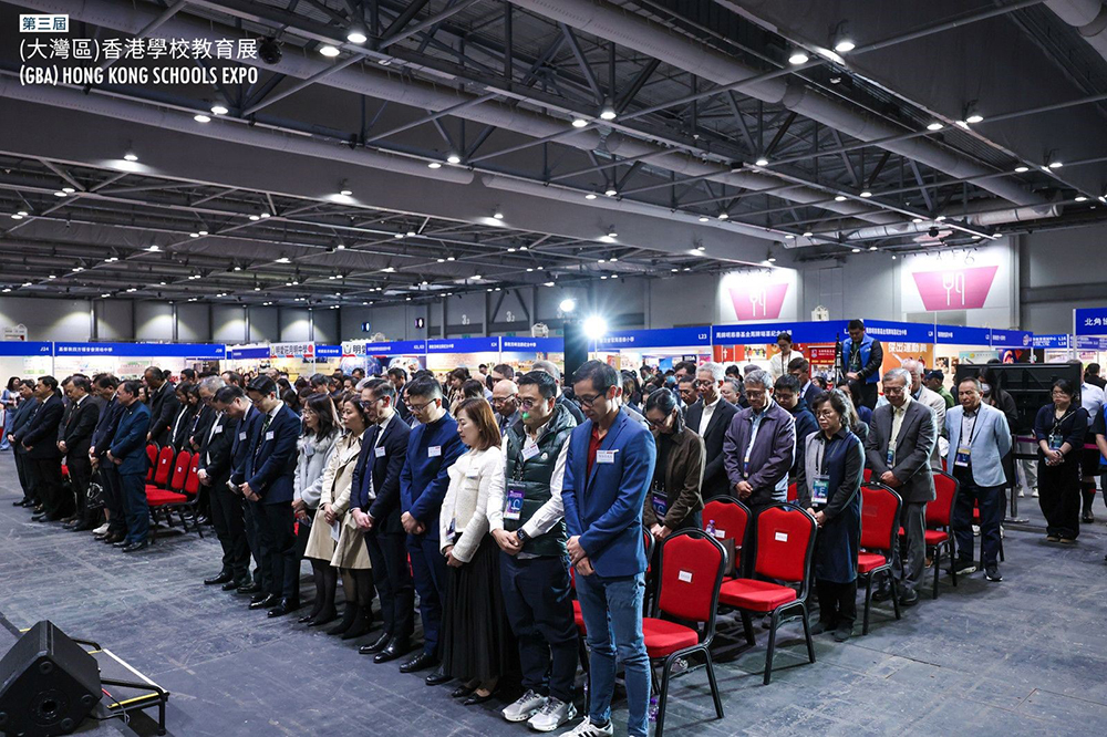 （大灣區）香港學校教育展開幕禮上，主禮嘉賓及出席人士均站立為大埔宏福苑大火默哀。