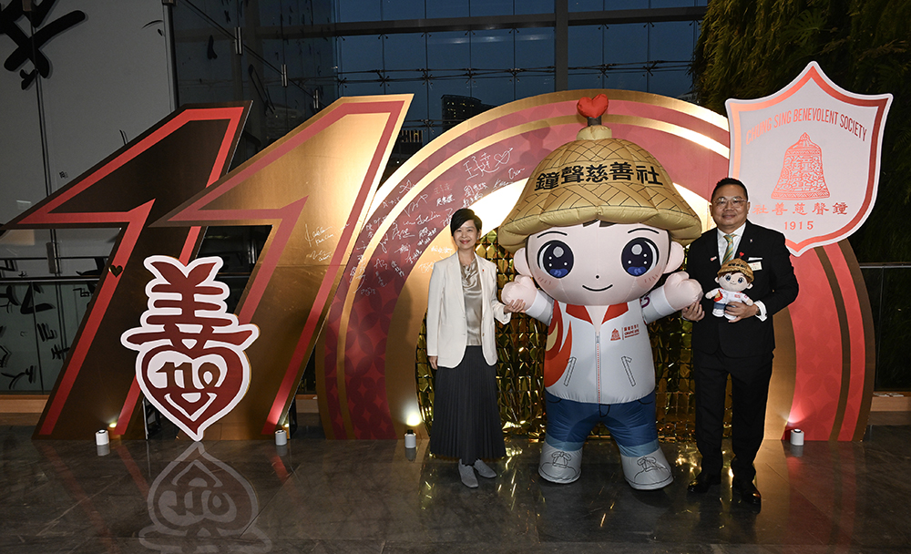 房屋局局長何永賢、鐘聲慈善社吉祥物「聲仔」、鐘聲慈善社社長王子達合照